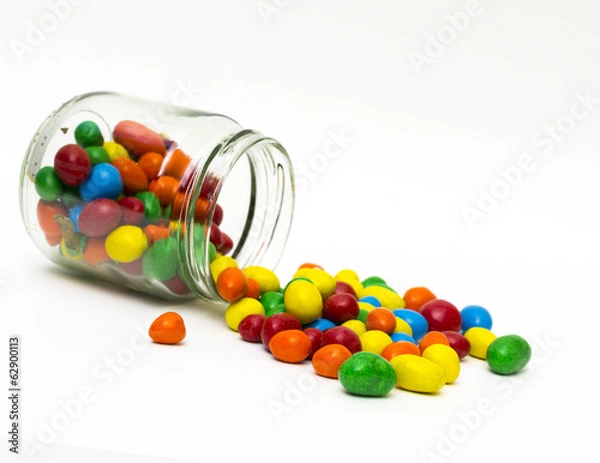 Fototapeta Isolated colorful candy out of jar on white background - selecti