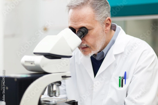 Obraz Scientist conducting research looking through microscope