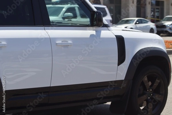 Fototapeta White SUV in motion closeup. Modern new SUV background image.