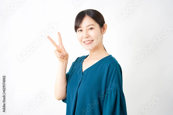 Fototapeta ピースサインするミドルエイジの女性　白背景