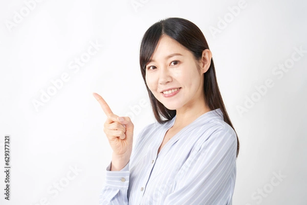 Fototapeta 左側を指差すミドルエイジの女性　白背景