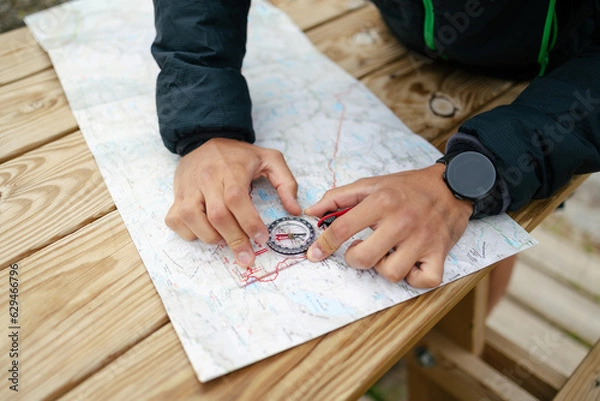 Obraz Close-up of man's hands using map and compass