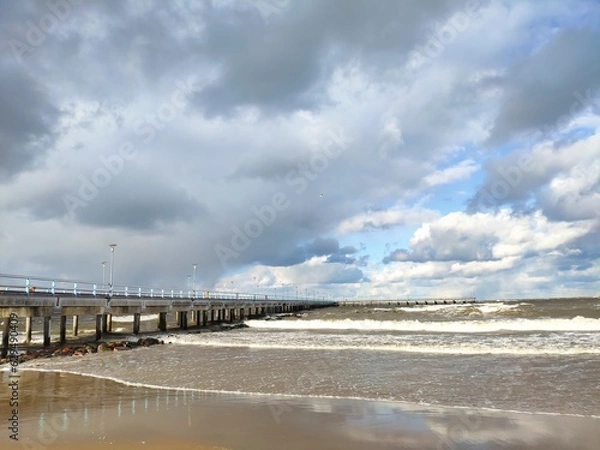 Obraz Winter beach with snow clouds and blue sky in day time water