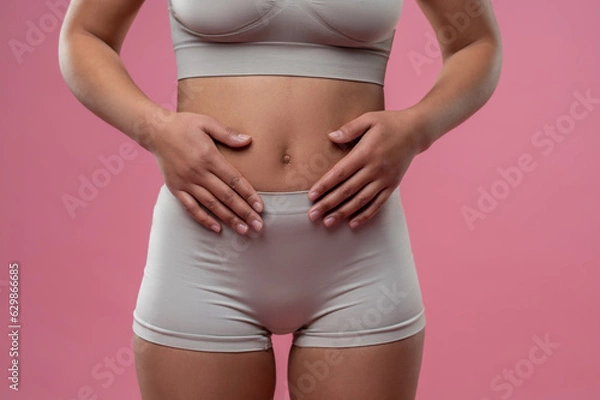 Fototapeta Woman in lingerie touching her belly