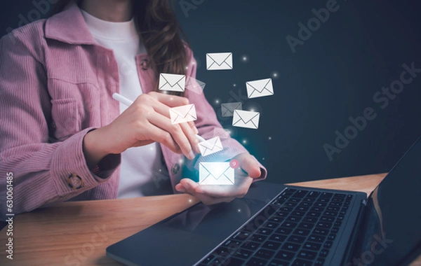 Fototapeta Businesswoman hand holding e-mail icon letter. Business e-mail communication and digital marketing. Inbox receiving electronic message alert. E-mail in virtual screen. New email notification concept.
