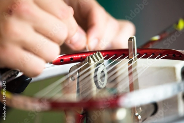 Fototapeta Closeup of a Japanese badminton weaving machine for repairing of broken badminton strings - a male hand weaves strings in a badminton racket head.