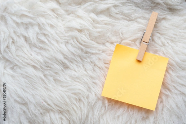 Fototapeta note paper with a peg laid on a sheep wool texture