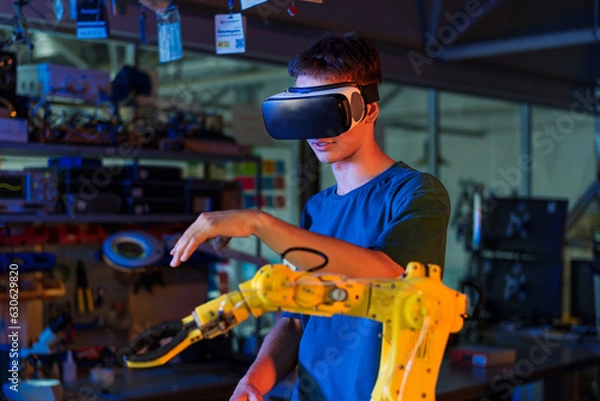 Obraz Teen remotely controlling robots in a laboratory