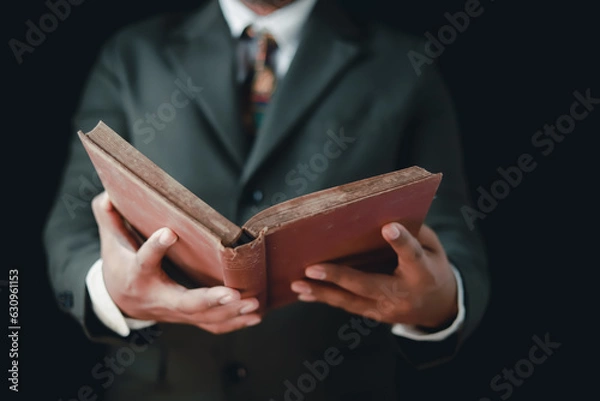 Obraz Asian man reading holy bible and crucifix according to divine teaching according to his faith and faith in god religious concept