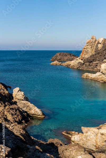 Fototapeta Cap de Creus Alt Emporda, Spain. February 2023 Rugged rocky coastline with turquoise waters in contrast. Sharp rocks extend out to the sea, creating a dramatic and wild texture.