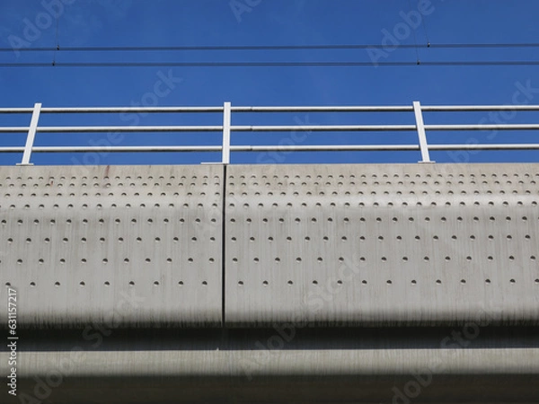 Fototapeta concrete railroadbridge with a dot pattern against a blue sky