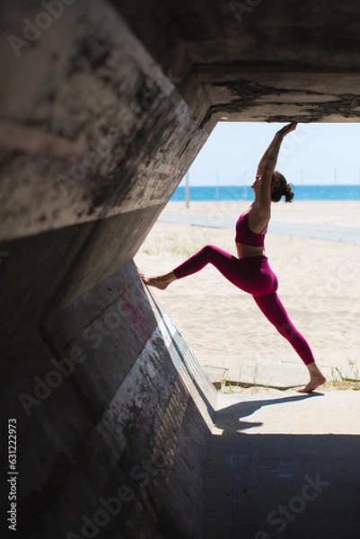 Fototapeta Woman doing pilates exercieses pose in concreate surround