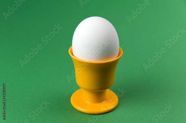 Fototapeta Egg in cup at green background