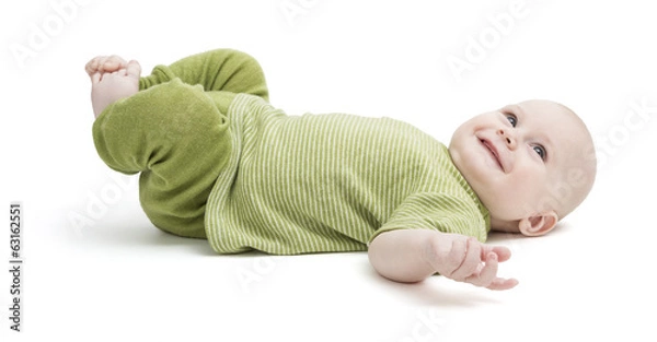 Fototapeta happy toddler lying on his back in green clothing