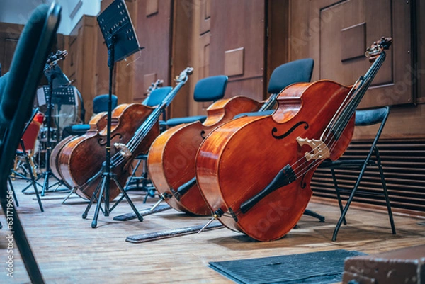 Fototapeta Classical musical instruments on stage. Orchestra pit, double basses, sheet music, opera house. Stringed instruments. Classical music concert.
