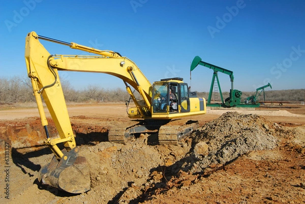 Obraz Excavator is doing dirt work for an oil well site.