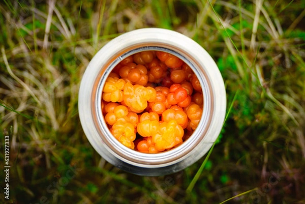 Obraz cloudberries in a flask - fresh after picking