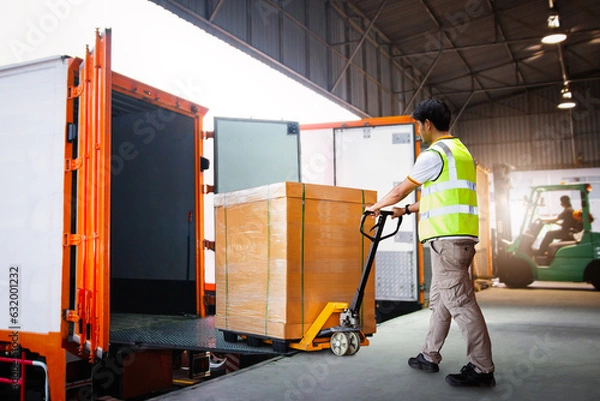 Fototapeta Workers Unloading Heavy Box into Container Truck. Trucks Loading Dock Warehouse. Supply Chain,  Package Boxes Shipment, Supplies Warehouse. Freight Truck Logistic, Cargo Transport, Warehouse Shipping.