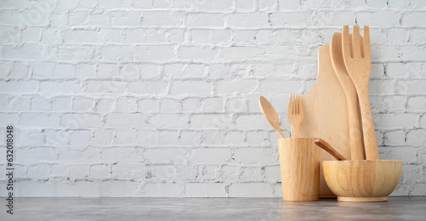 Obraz Kitchen table with wooden kitchenware set on brick wall texture background.	
