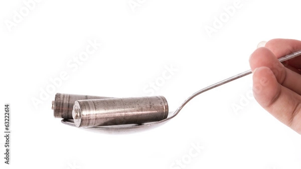 Fototapeta isolated of old AA battery in spoon is energy consumption concep