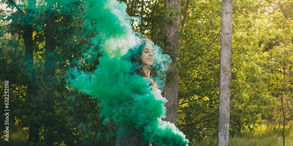 Obraz Girl with smoke bomb makes saturated green clouds of smoke.