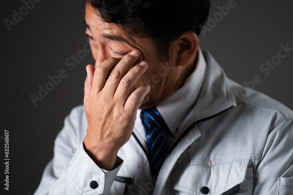 Fototapeta 悲しんでいるミドル男性　作業服イメージ