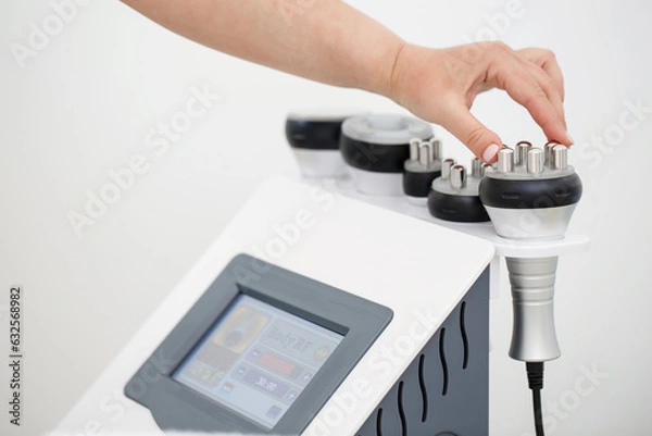 Fototapeta RF body cavitation lifting procedure in a beauty salon. Ultrasound therapy to reduce fat and elasticity of the skin. Cosmetic ultrasonic anti-cellulite massage close-up