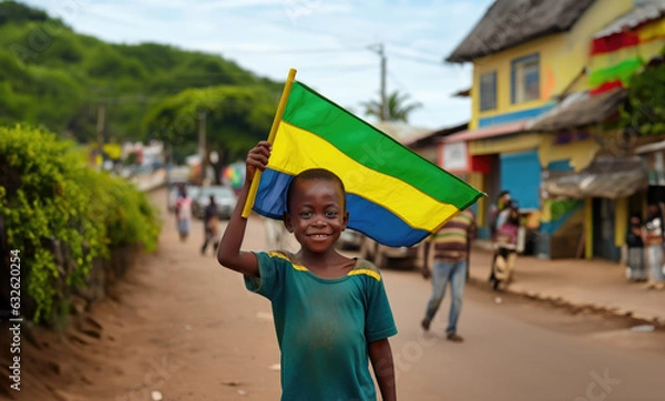 Fototapeta Un garçon gabonais tenait un drapeau de la république du Gabon dans sa main, dans une rue de Libreville