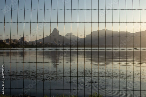 Fototapeta Rodrigo de Freitas lagoon  (Lagoa Rodrigo de Freitas) seen from behind the bars during sunset in Rio de Janeiro.