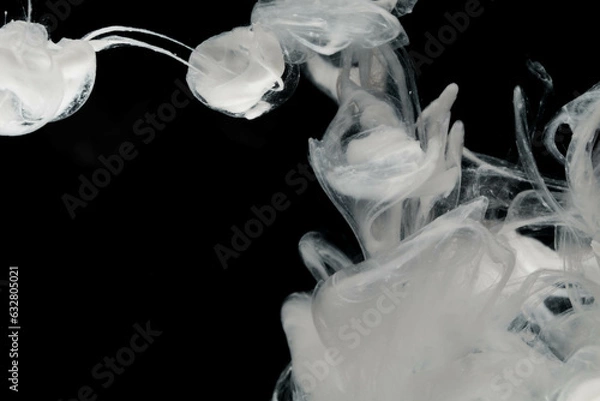 Fototapeta Abstract paint splash isolated on black background. Acrylic ink in water. selective focus.