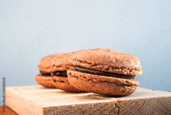 Obraz Chocolate flavor Macaroon placed on wood and leather