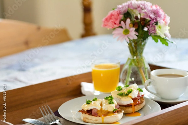 Obraz Eggs Benedict on breakfast tray on bed