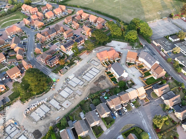 Obraz Aerial view looking on an area of new build housing construction on the edge of existing houses and green fields