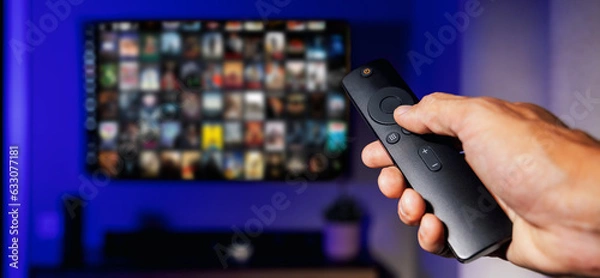 Fototapeta Zdalne sterowanie w ręku i telewizji z listą filmów na ekranie na tle. Streaming Media Service, treści na żądanie. Baner z przestrzenią kopii
