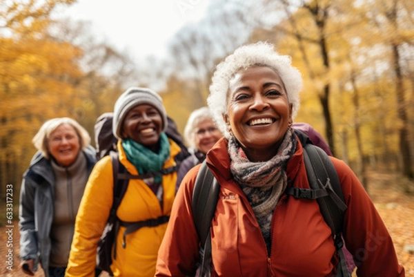 Obraz Group of active seniors tourists walking in autumn forest or park together.