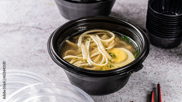 Obraz The concept of oriental cuisine. Takeaway Chinese food. chicken soup with pasta, noodles and egg in a disposable box. food delivery