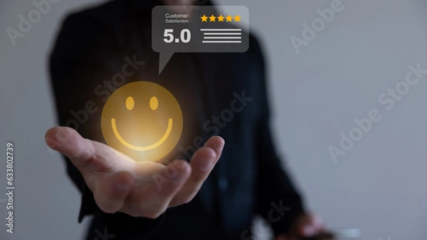 Fototapeta Businessman holding virtual smiley face with five stars and using computer laptop for online evaluation product and service , customer satisfaction concept.