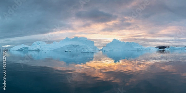 Fototapeta Iceberg at sunset. Nature and landscapes of Greenland. Disko bay. West Greenland. Summer Midnight Sun and icebergs. Big blue ice in icefjord. Affected by climate change and global warming concept.