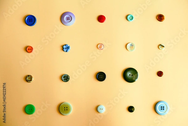 Fototapeta various types of buttons layed out on an orange background