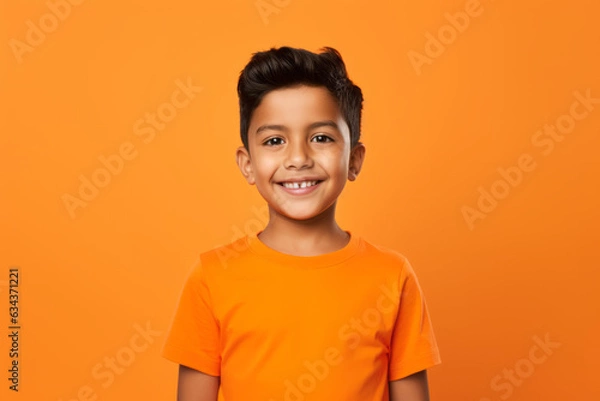 Fototapeta Smiling Mexican Boy on Vibrant Orange Studio Background