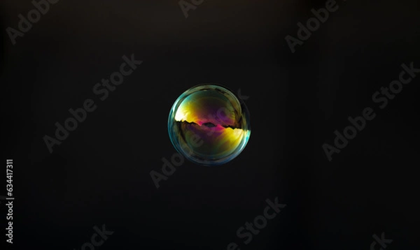 Fototapeta Cyan gold soap bubble on blurred dark background. Close-up.