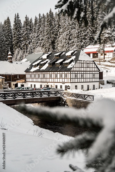 Fototapeta Winter Modrava and old historical building with wooden bridge, Sumava mountains