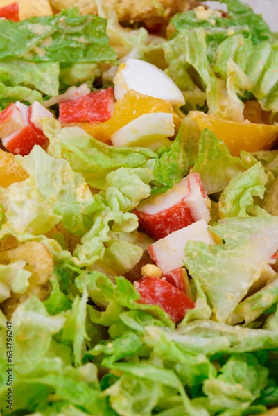 Obraz Salad with crab sticks, tomatoes, napa cabbage, eggs, lettuce and croutons close up. Macro shot.