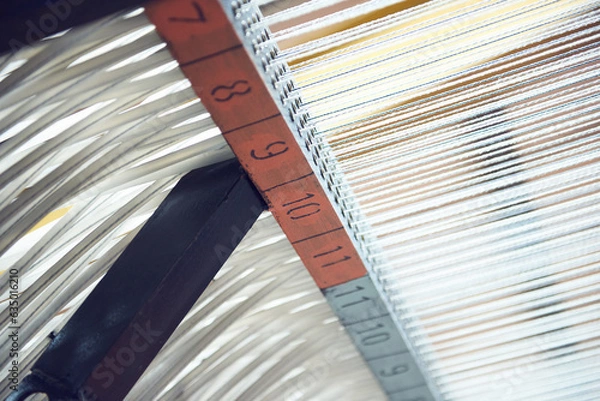 Fototapeta Cotton threads in industrial cotton in a weaving factory, machine weaving cotton for the fashion and textiles industry. Yarn weave traditional textile fabric manufacturing for clothing and fashion.