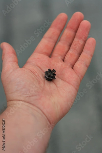 Fototapeta Military drone detail on palm, close up shot. Civil person holding a fragment from unmanned aerial vehicle after shelling. War aftermath