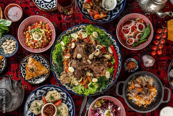 Obraz Traditional Uzbek oriental cuisine. Uzbek family table from different dishes for the New Year holiday. The background image is a top view.