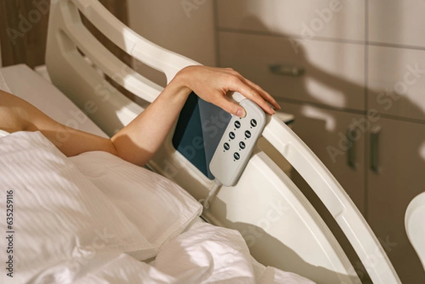 Fototapeta Close up of woman patient hand presses the buttons on the hospital bed. High quality photo