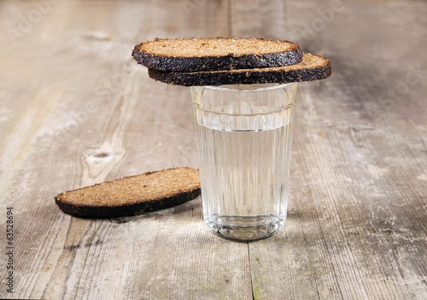 Fototapeta Glass with water and bread