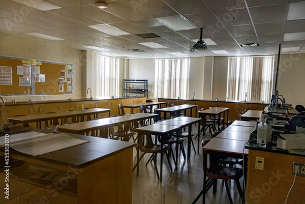 Fototapeta Science laboratory classroom - wooden lab tables with black countertops and sinks - windows with closed blinds - bulletin board and chalkboard. Taken in Toronto, Canada.