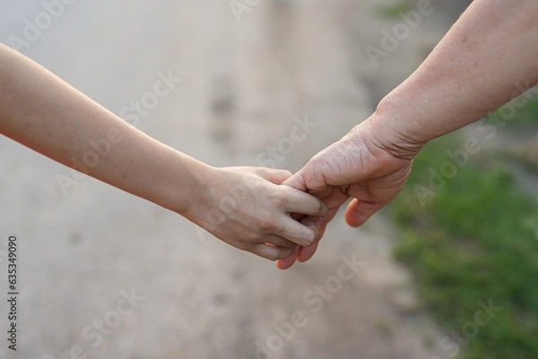 Fototapeta parent holds the hand of a small child